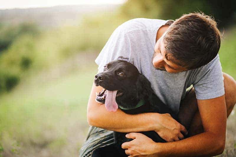Black lab being hugged Black lab being hugged